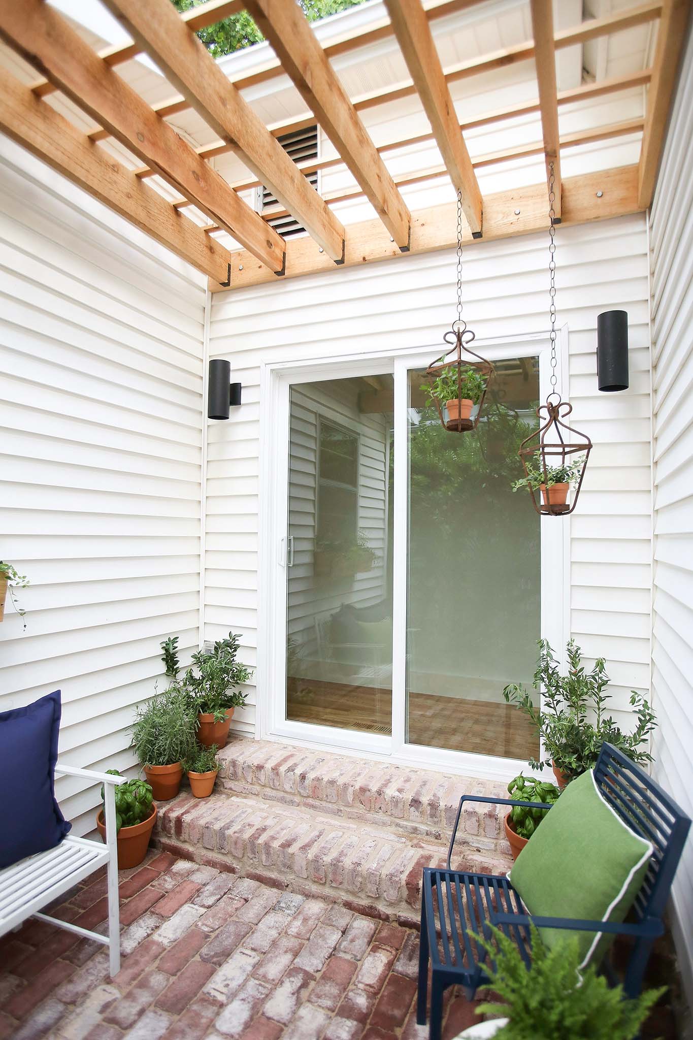 French Doors lead to a cozy porch with custom built pergola.