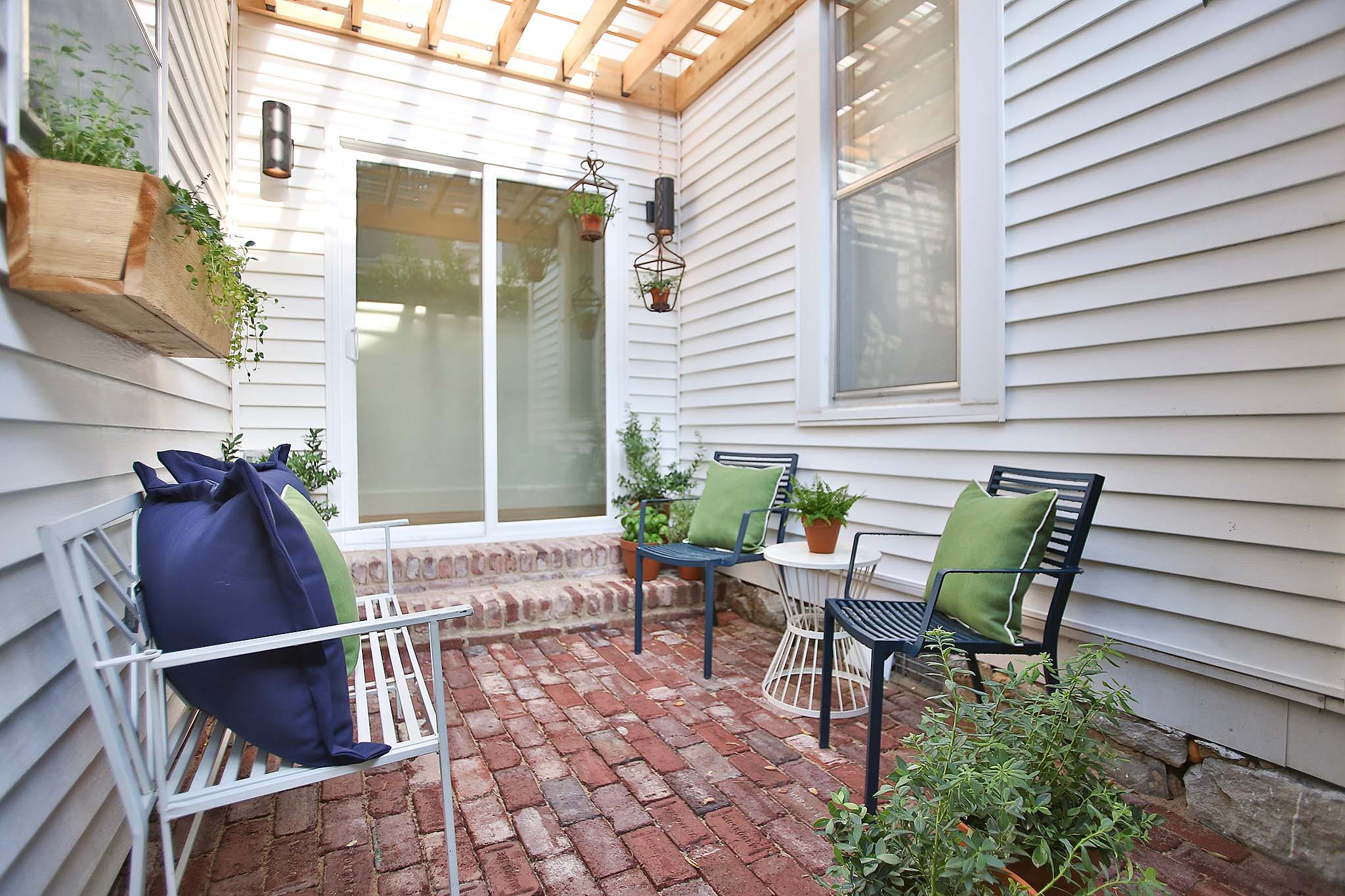 French Doors lead to a cozy porch with custom built pergola.