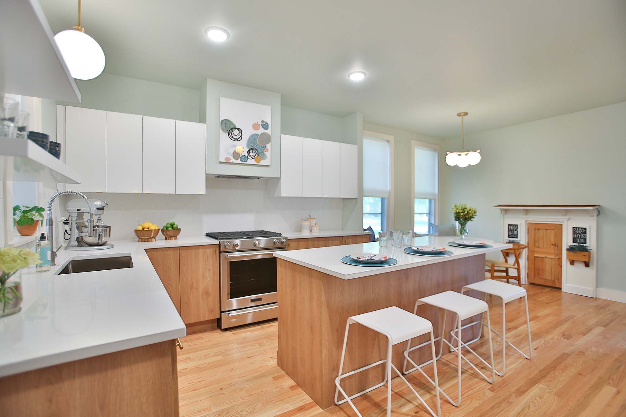 Modern and mid century kitchen using white laminate cabinets and white counter tops with large kitchen island.