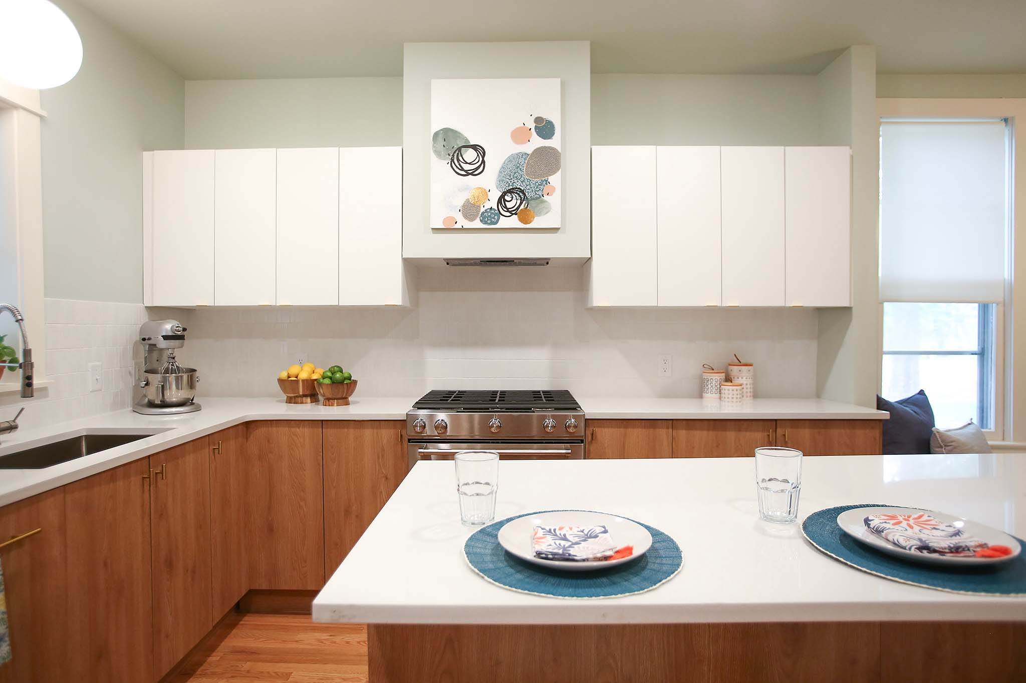 Bright laminate cabinets and white counter tops give this kitchen a modern and mid century feel.