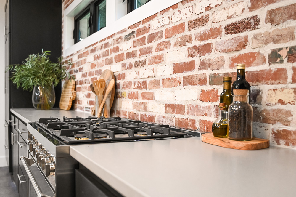 HGTV Fixer to Fabulous Kitchen Renovation with brick backsplash and large kitchen island.