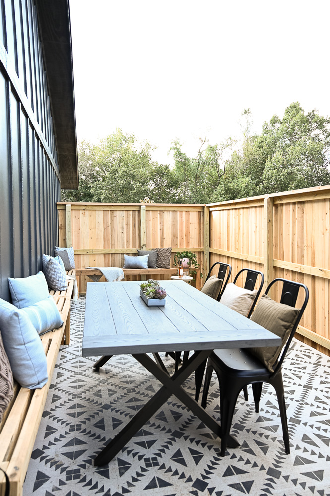 HGTV Fixer to Fabulous Patio Renovation with L-shaped bench and painted concrete.