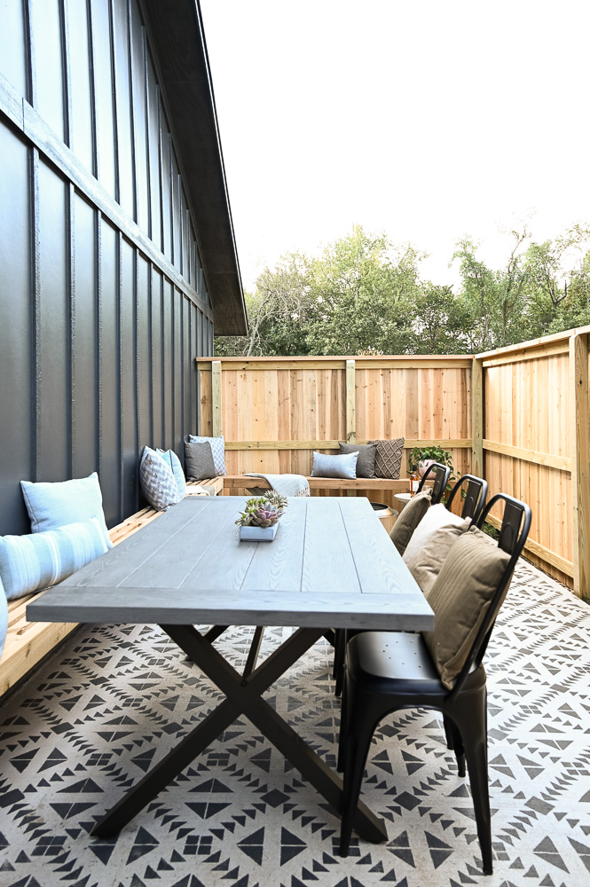 HGTV Fixer to Fabulous Patio Renovation with L-shaped bench and painted concrete.