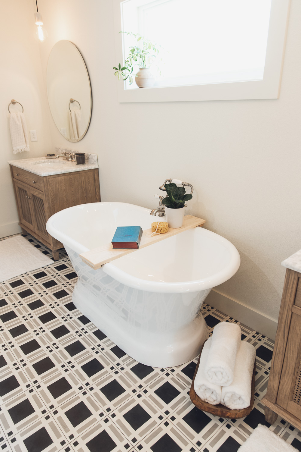 HGTV Fixer to Fabulous Lake House Bathroom with free standing tub and patterned tile floor.