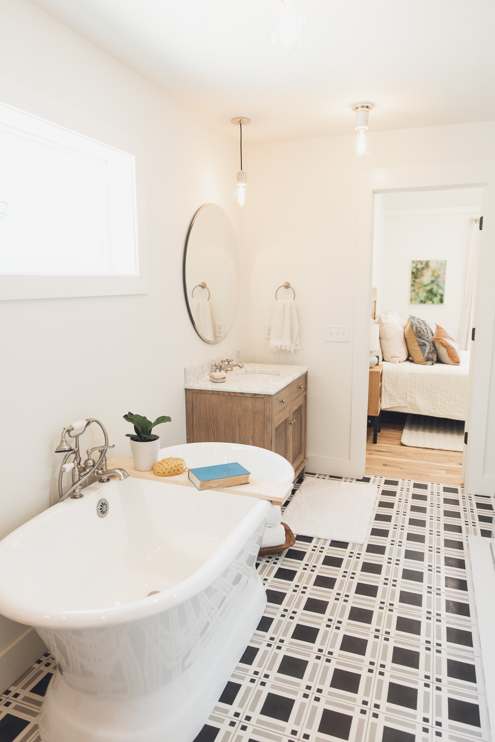 HGTV Fixer to Fabulous Lake House Bathroom with free standing tub and patterned tile floor.