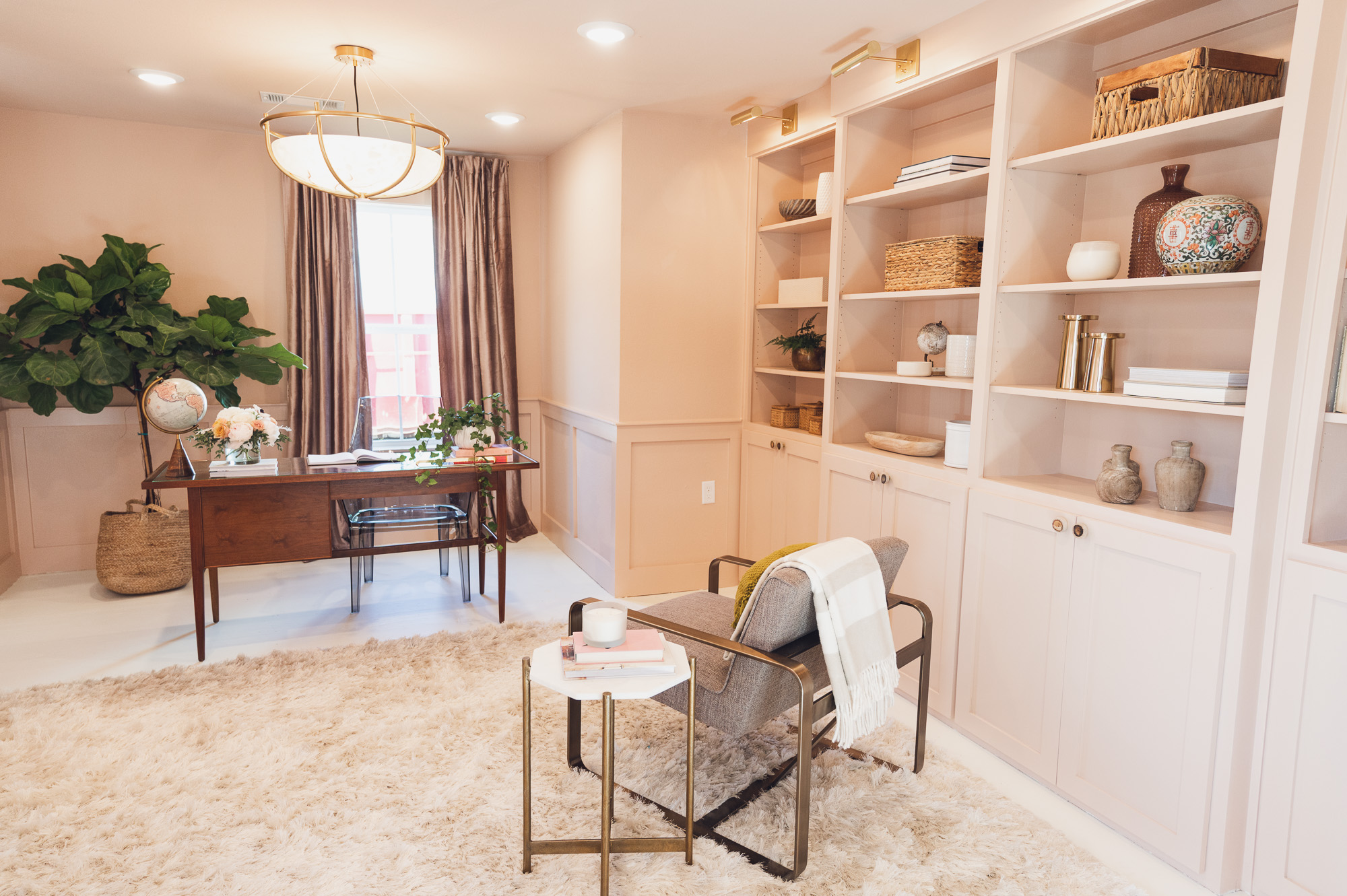 Remodeled study with light pink walls and built-ins displaying books and items