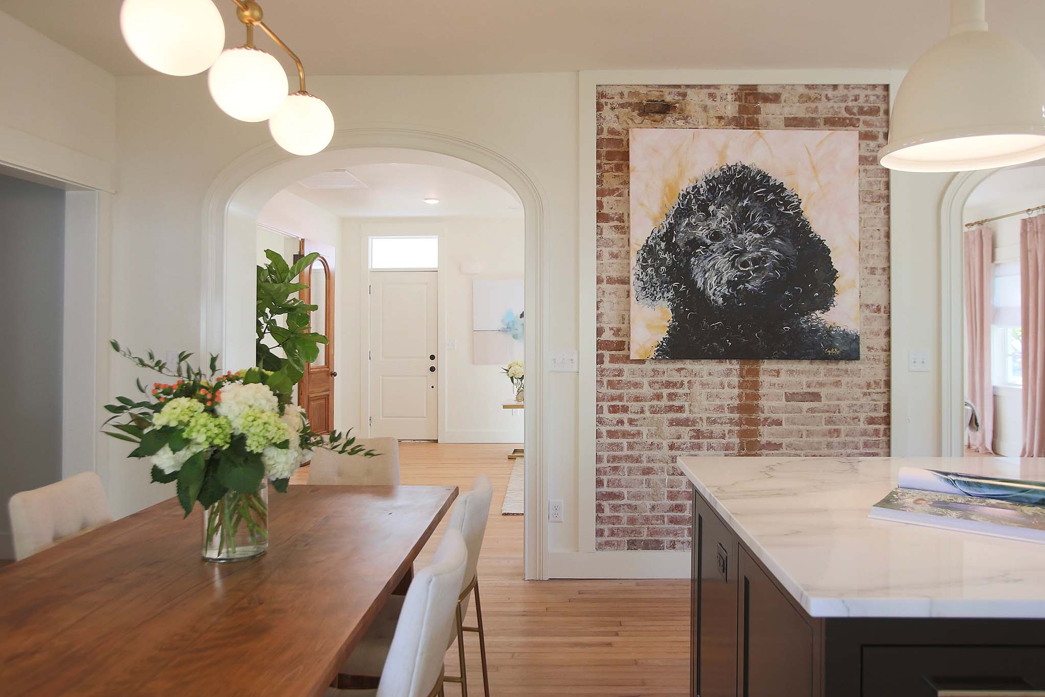 Custom painted art in this renovated kitchen with exposed brick.