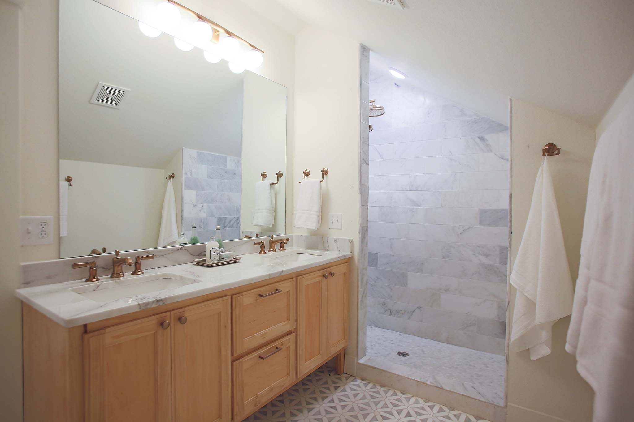 Custom shower and double vanity in this bathroom renovation on HGTV Fixer to Fabulous.