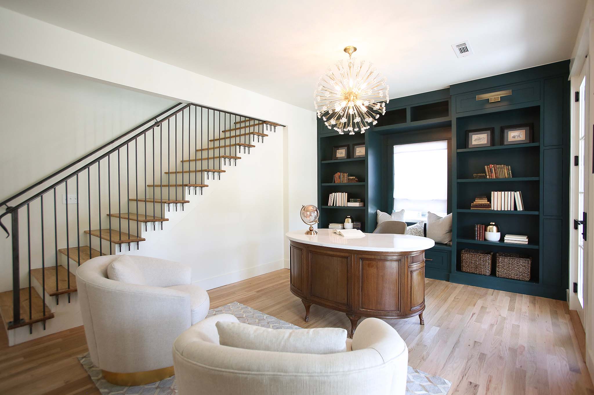 Custom iron railing, built in book shelves and refurbished antique desk round out this home office on HGTV Fixer to Fabulous.